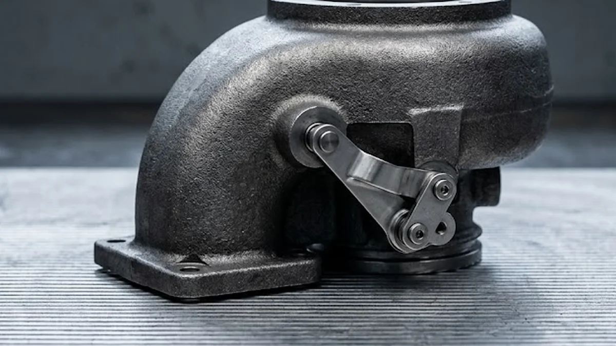 Gusseisernes Turbinengehäuse mit Steuerhebel der variablen Turbinengeometrie zur Prüfung mechanischer Leichtgängigkeit.
